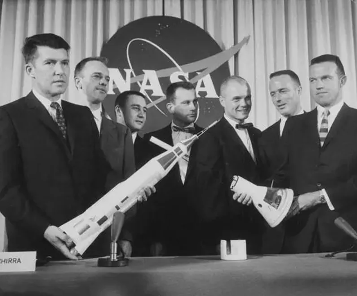 The Mercury 7 astronauts pose with a model rocket at their historic 1959 debut. 